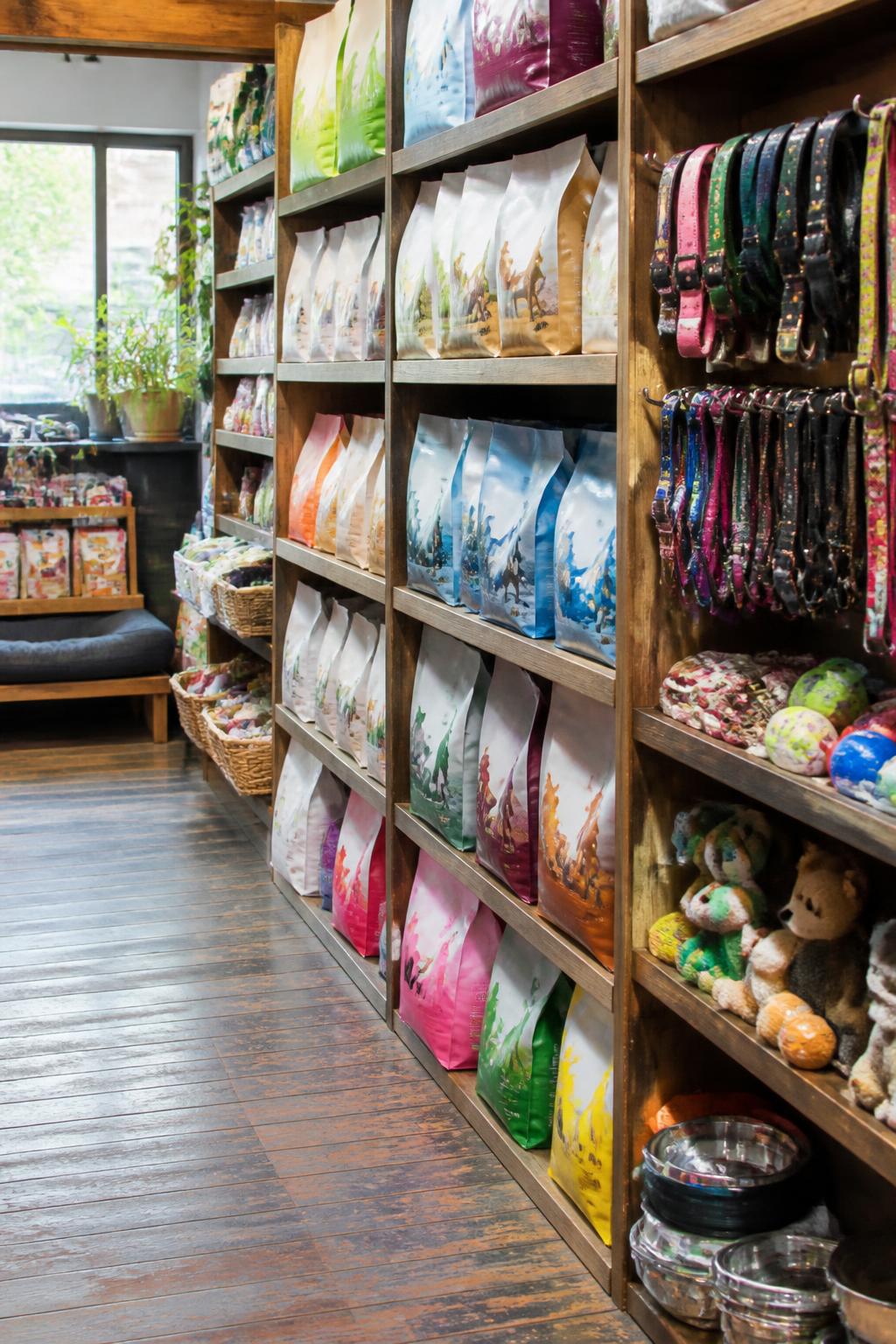 Stocked shelves of pet food, collars and toys in an independent store